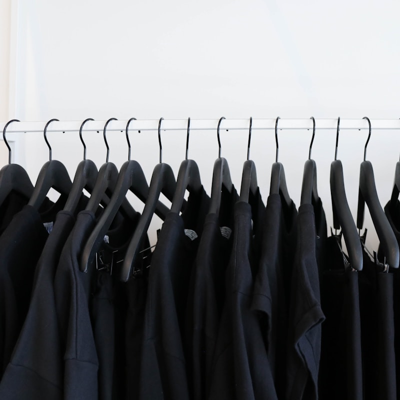Row of black garments hanging on a rail